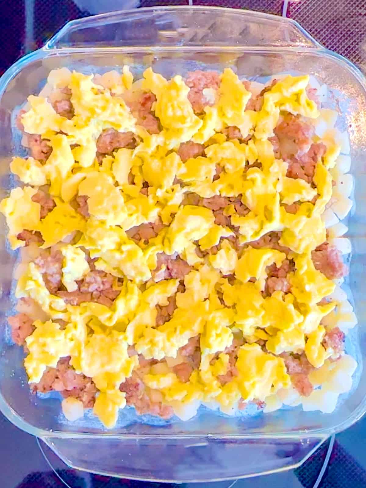 Potatoes, breakfast, sausage, and eggs in a glass dish.