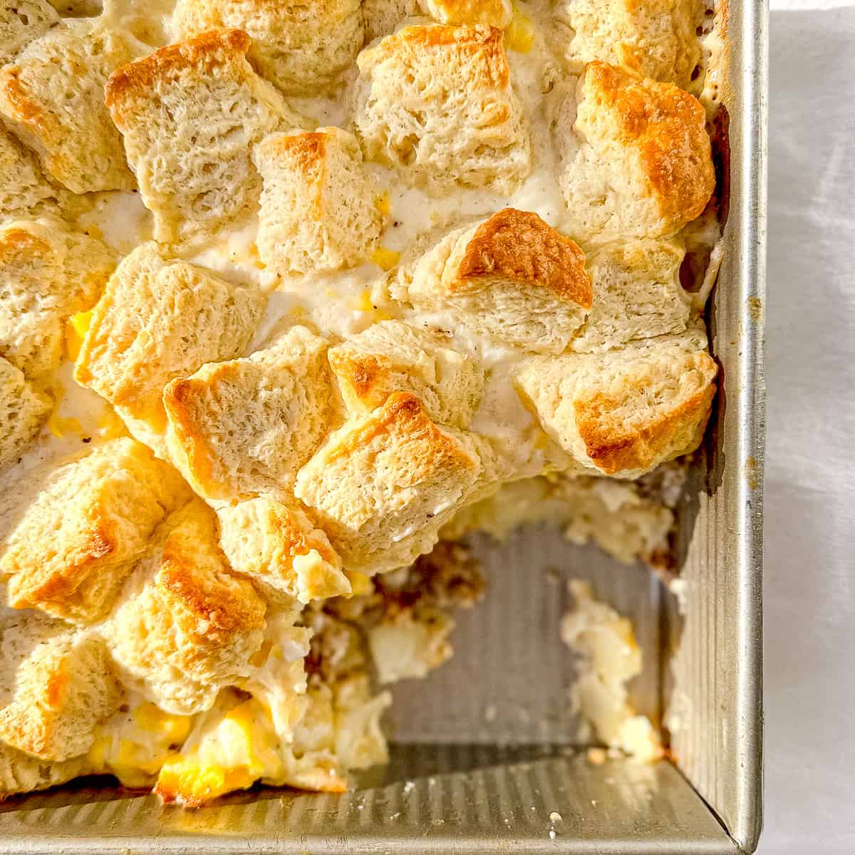 Serving up a Biscuits and Gravy breakfast casserole topped with homemade buttermilk biscuits.