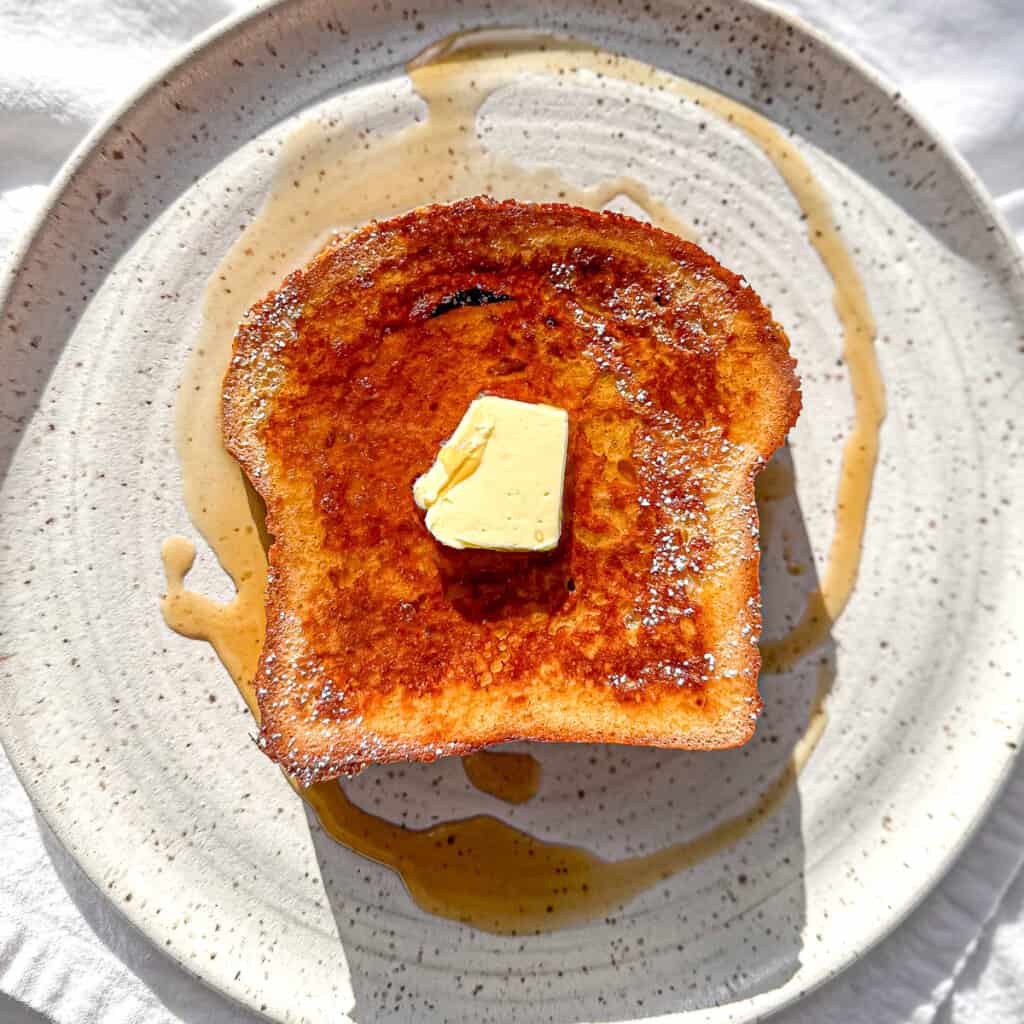 One slice of eggnog French toast on a white plate.