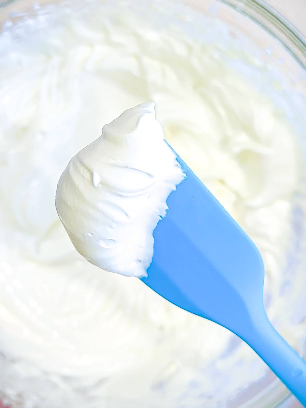 Fluffy whipped Greek yogurt cream on a spatula.