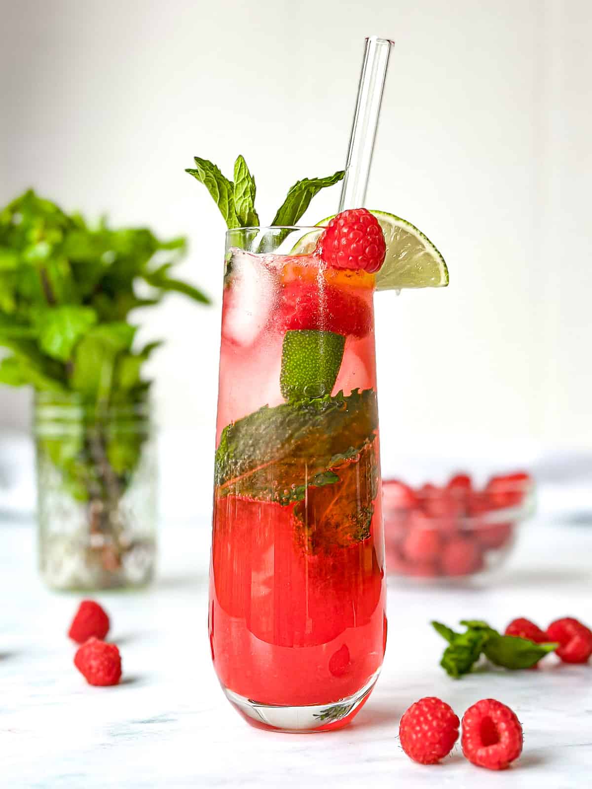 Raspberry Mojito Mocktail in a tall champagne flute.