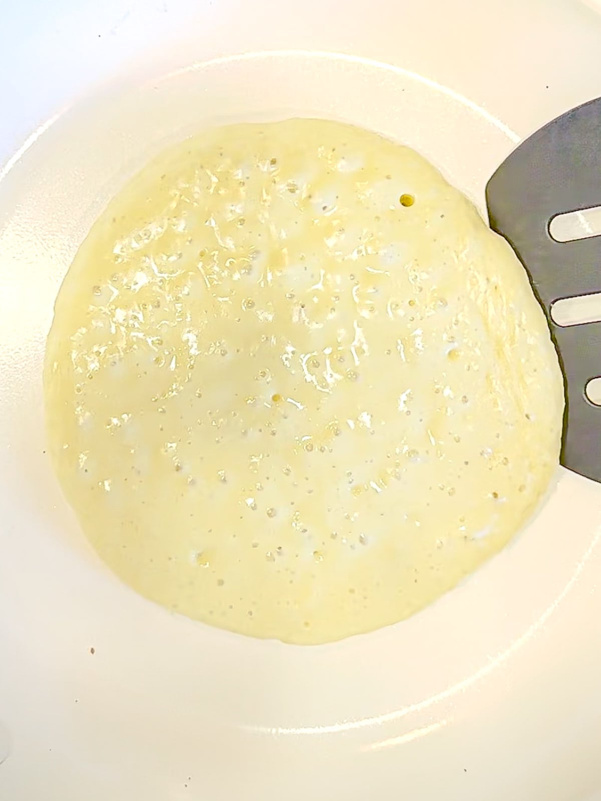 Using a spatula to flip over a three ingredient pancake.