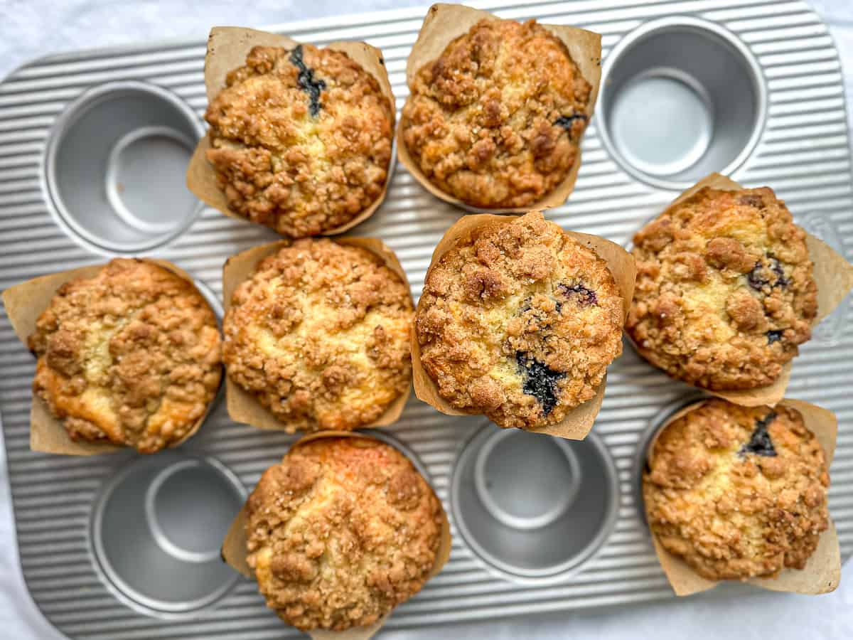 Bakery style, blueberry, streusel muffins in a muffin pan.