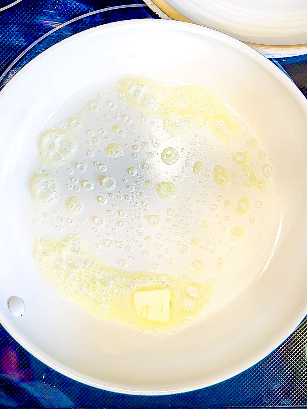 Melting butter in a nonstick pan to make scrambled eggs.