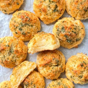 Cheddar Bay biscuits on a parchment paper covered pan.