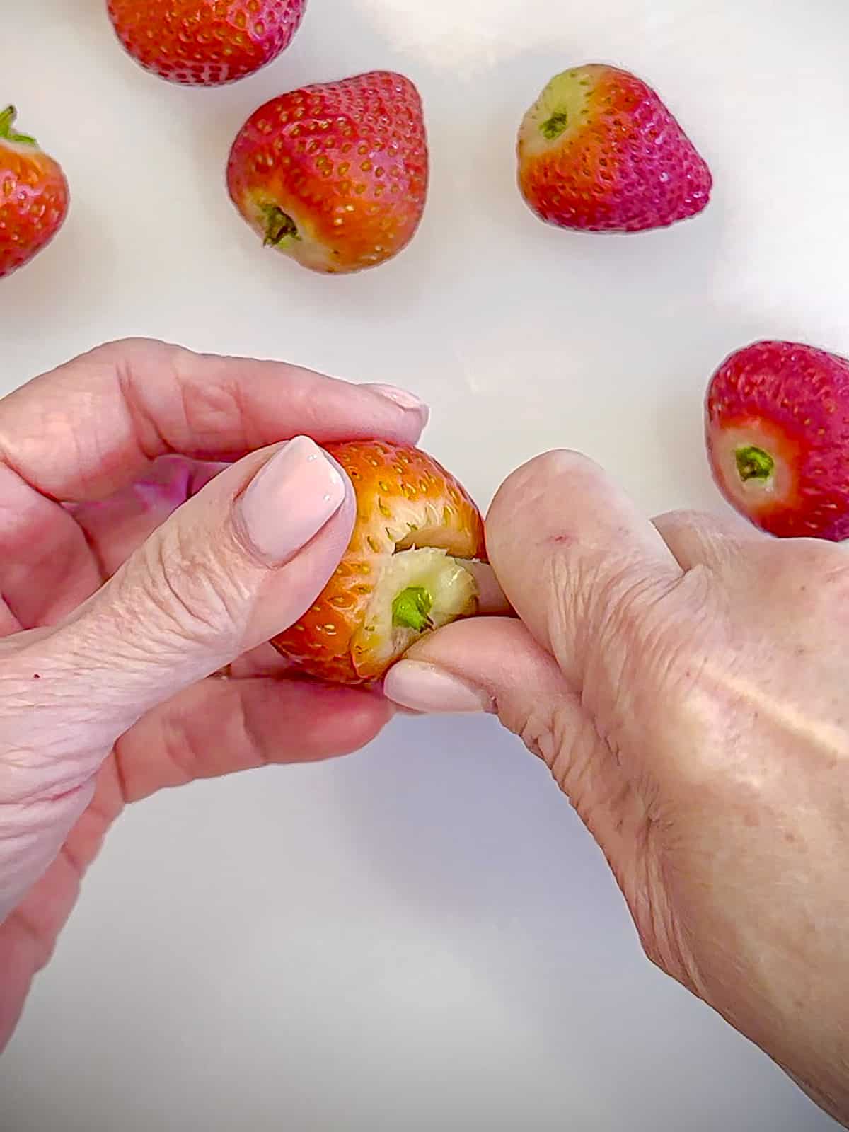 Using a paring knife to hull a strawberry.