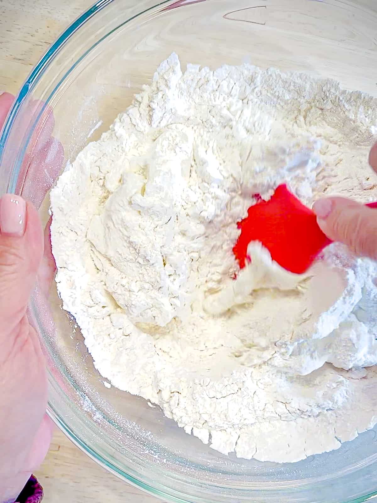 Combining Greek yogurt and self rising flour together in a bowl.