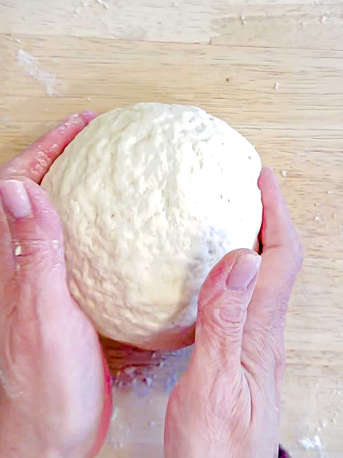 Shaping a batch of 2 Ingredient bagel dough into a large ball.