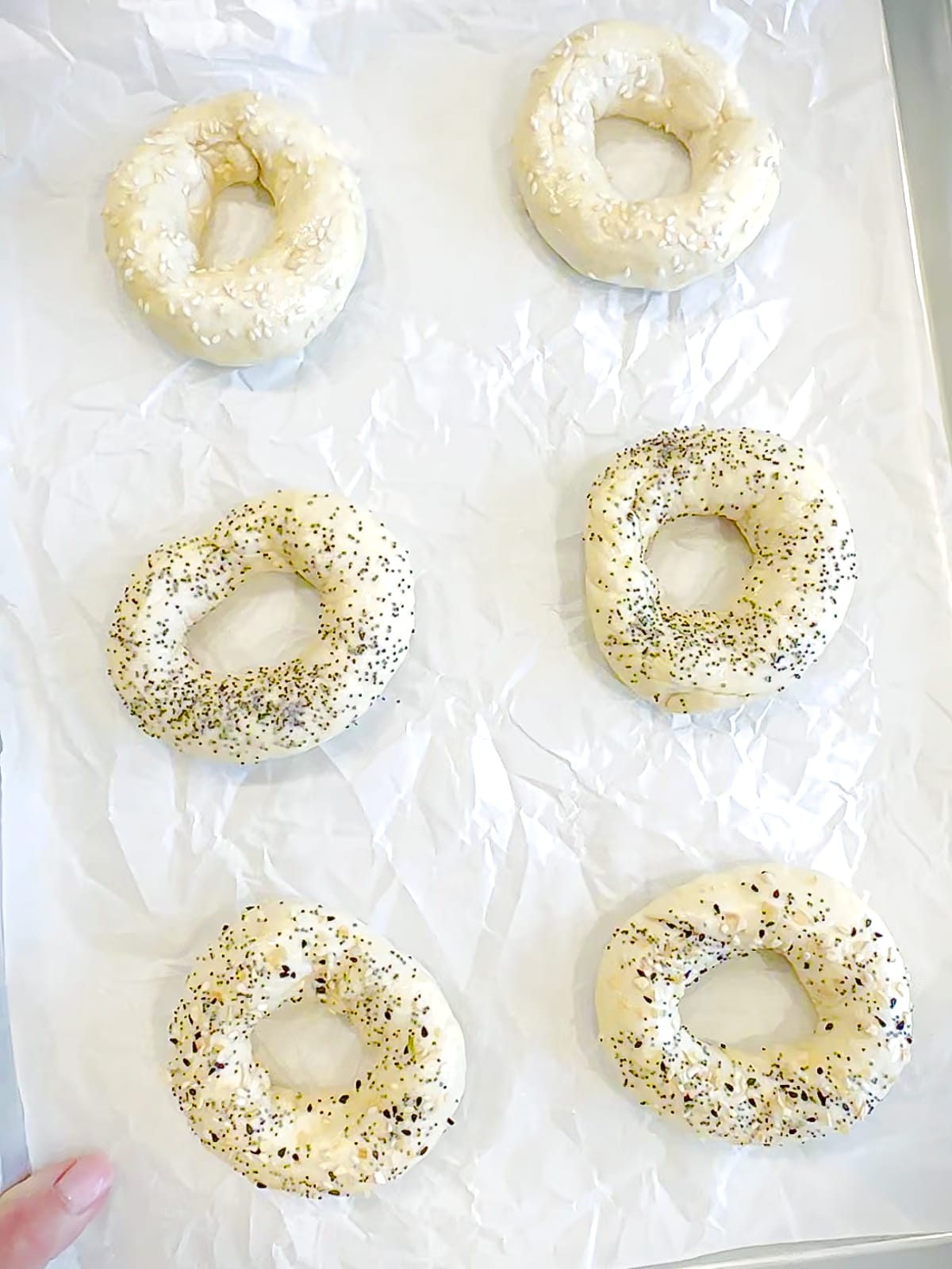 Unbaked two ingredient bagels with toppings, ready to go into the oven.