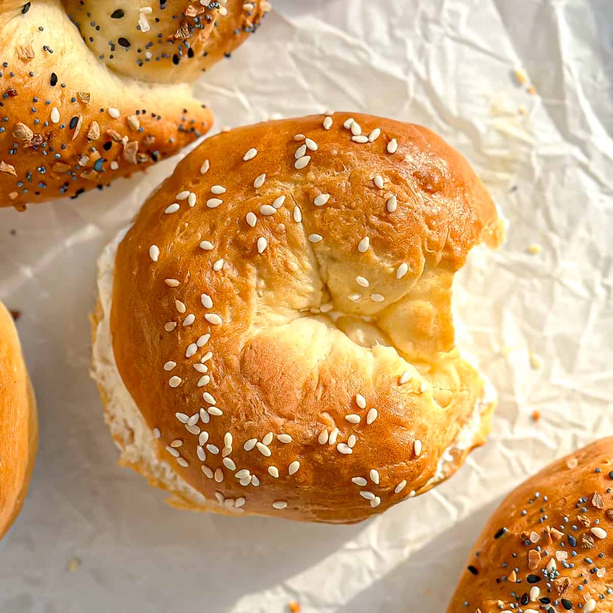 A sesame seed 2 Ingredient bagel with cream cheese with a bite taken out.