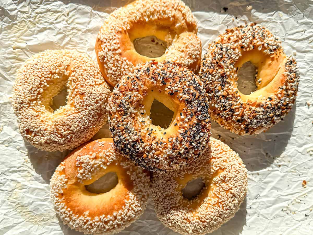 A pile of bagels on parchment paper..