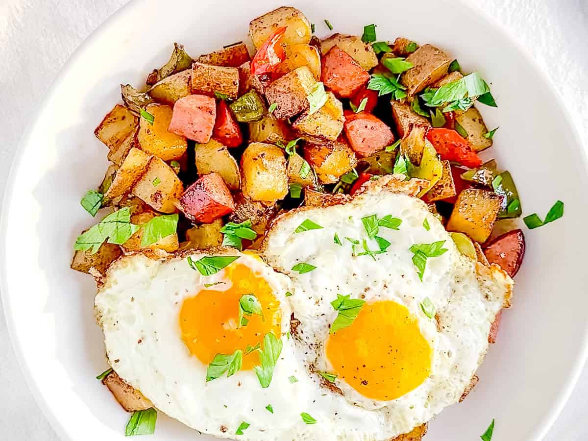 Sausage potato hash with two fried eggs.