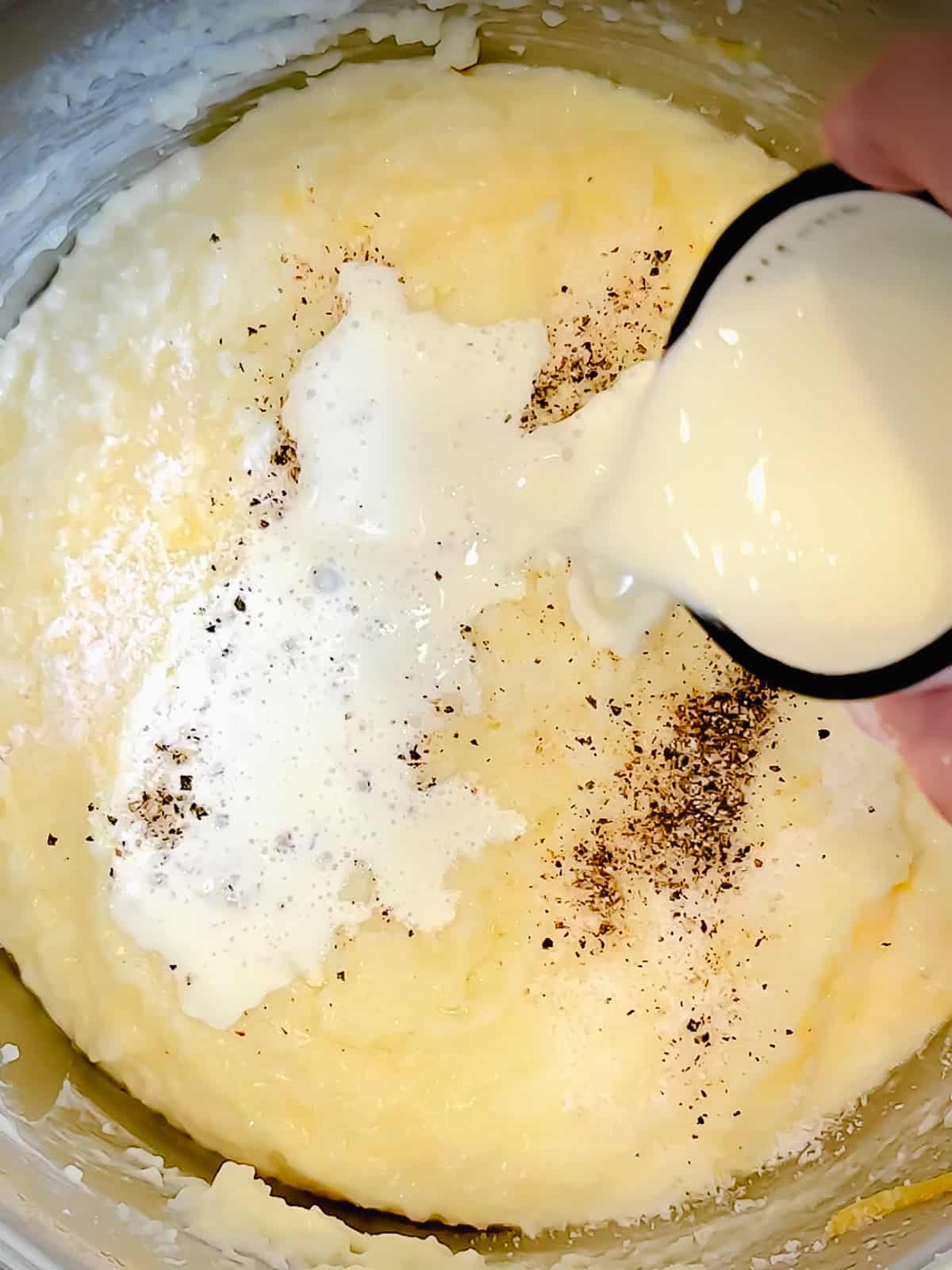 Adding heavy cream to cheese grits before serving.