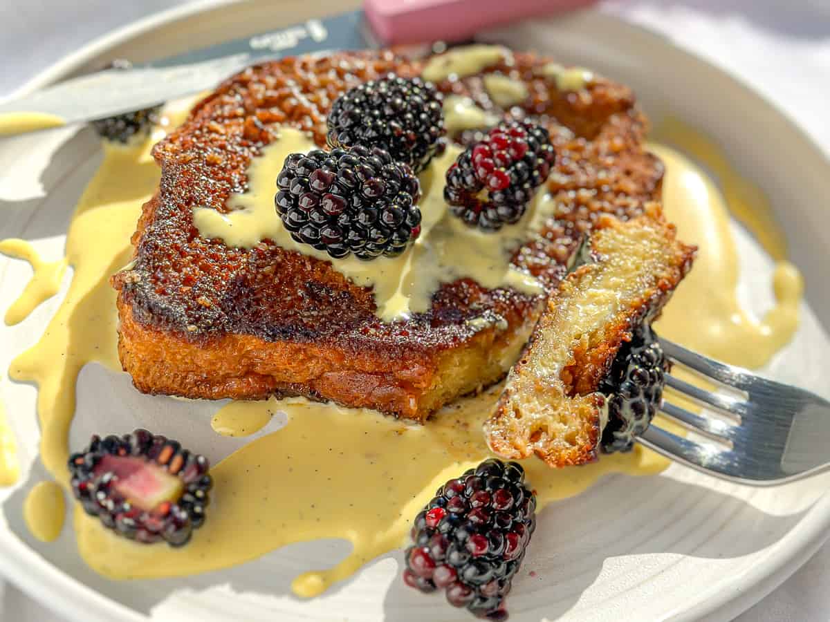 French toast drizzled with crème anglaise and blackberries.