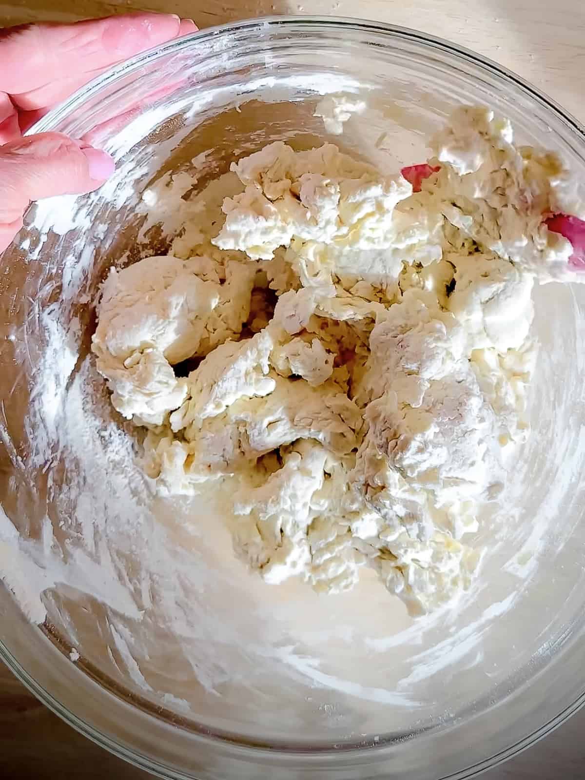 Mixing together self rising flour and Greek yogurt.