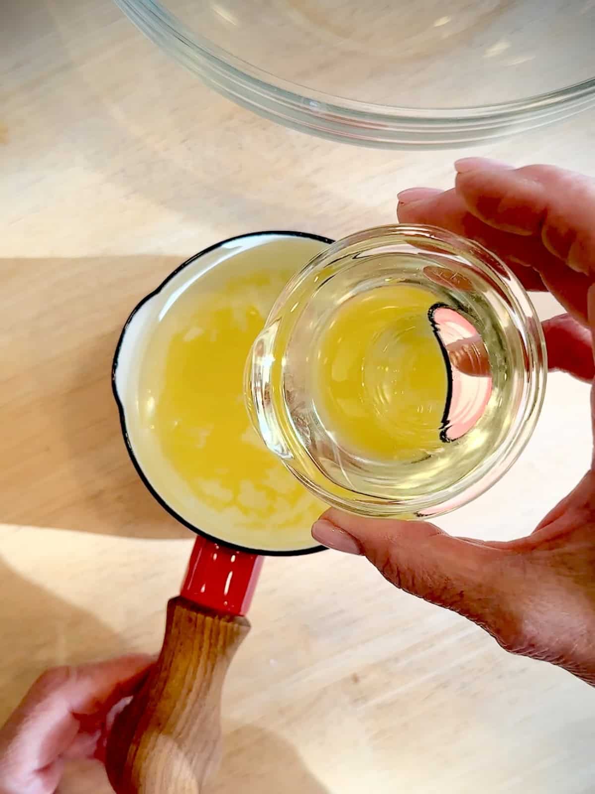 Adding oil to hot melted butter to cool it off.