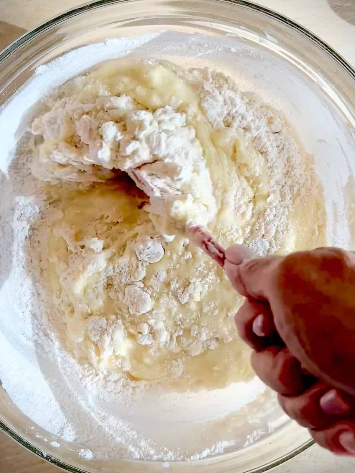 Folding flour into wet ingredients.