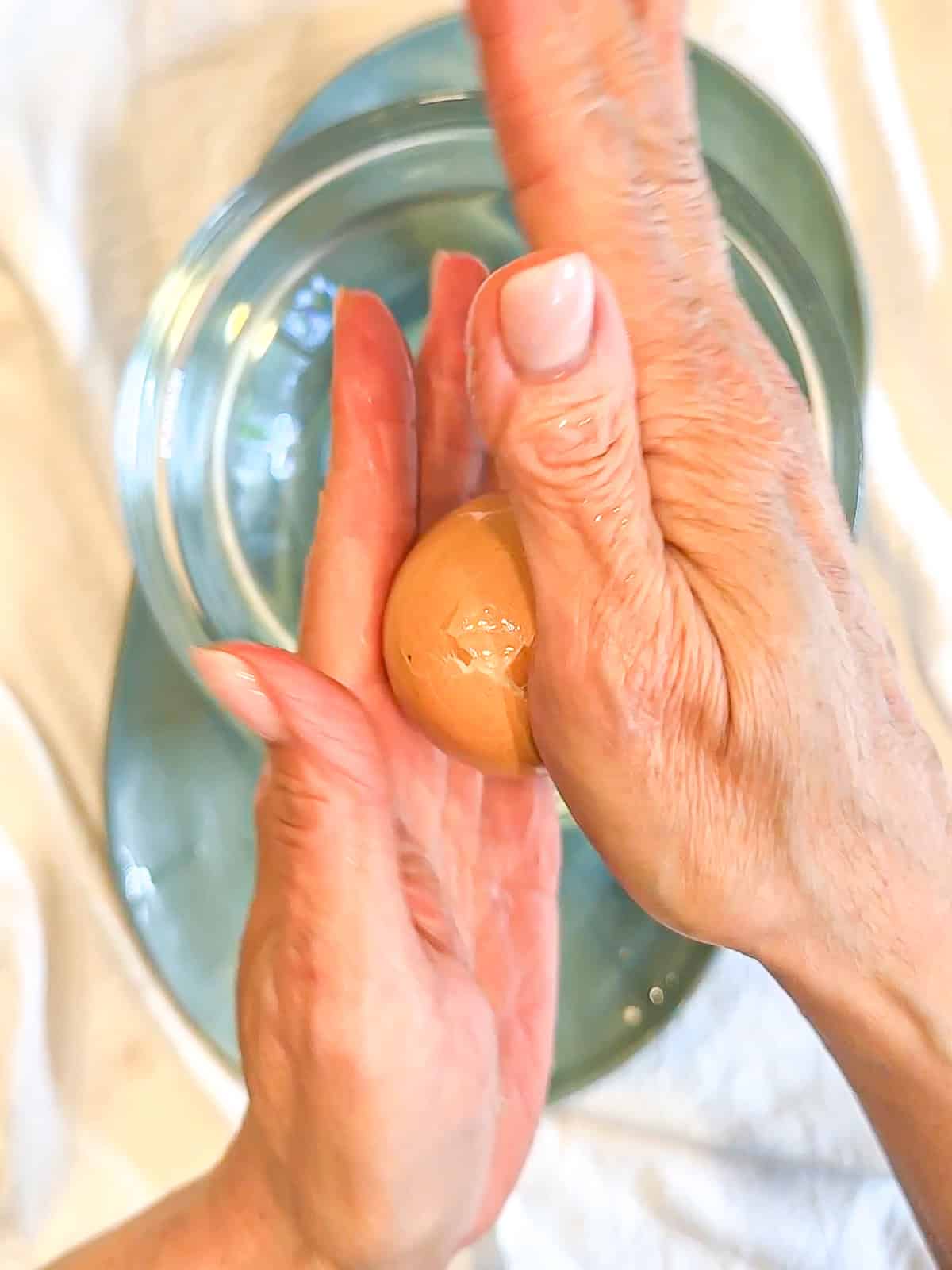 Rolling a hard boiled egg between my hands to crackle the shell.