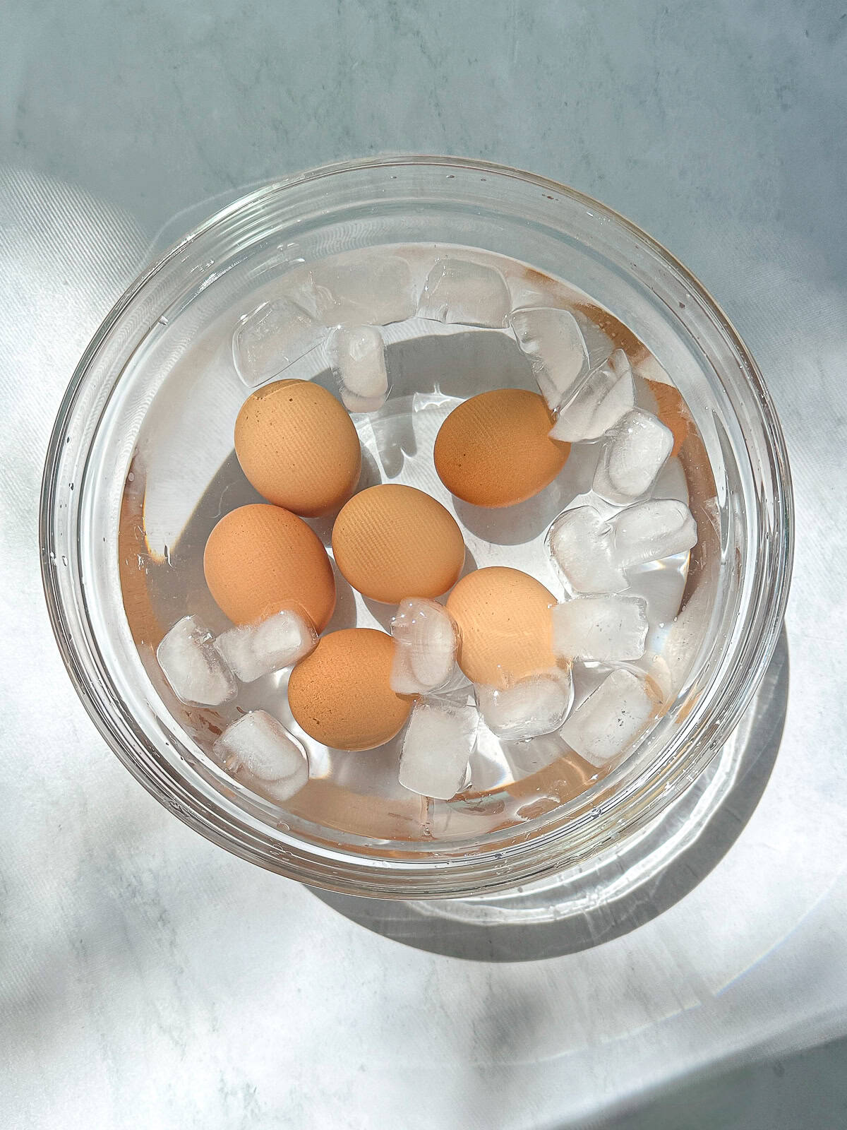 Boiled eggs in a bowl of ice water.