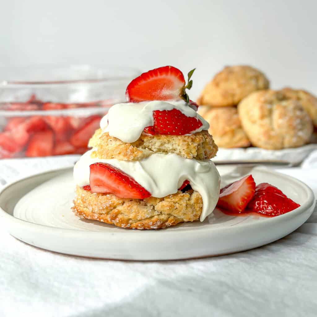 Horizontal image of biscuit strawberry shortcake on a white plate.