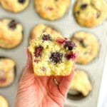 The author holding a mixed berry muffin in her hand with the interior exposed.