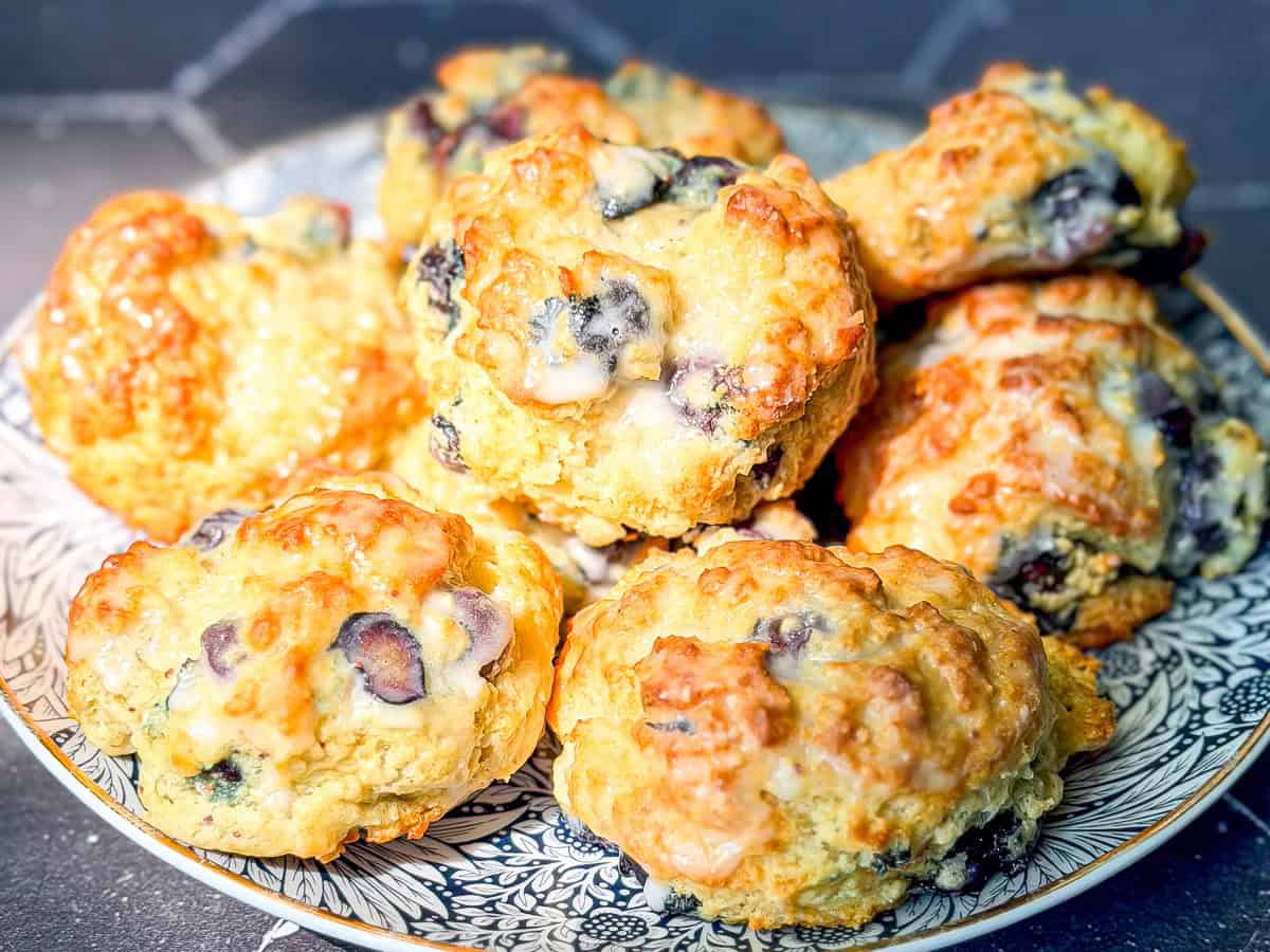 Glazed blueberry drop biscuits on a plate.