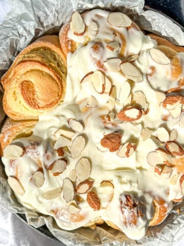 Almond sweet rolls covered with cream cheese frosting and sliced almonds.