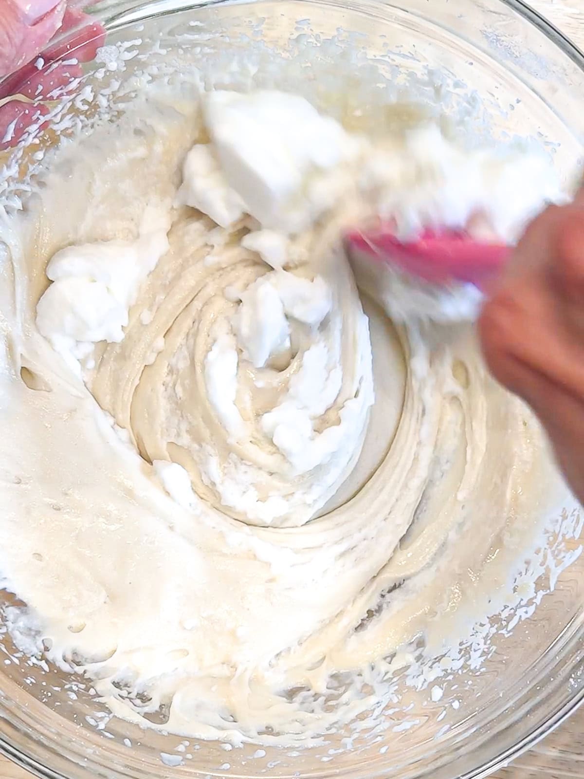 Folding egg whites into coconut cake batter.