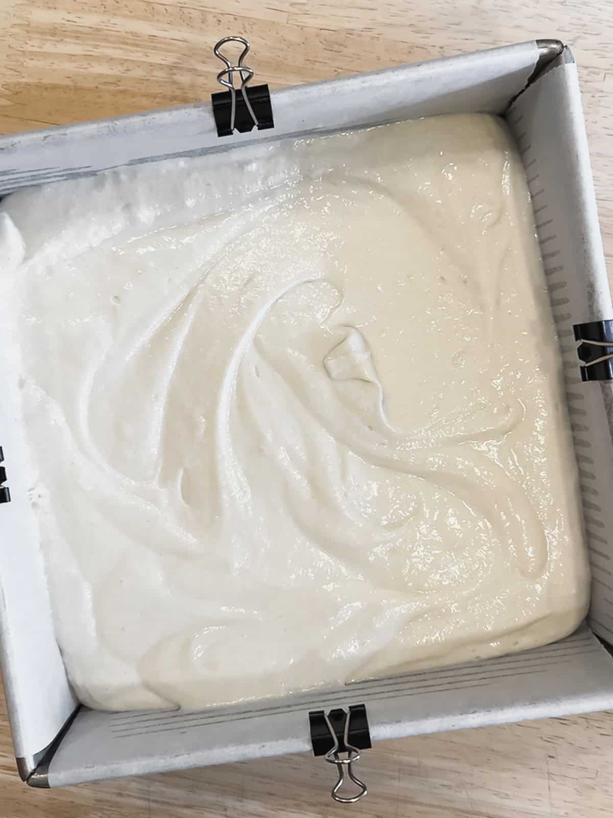 Spreading coconut cake batter in a pan.