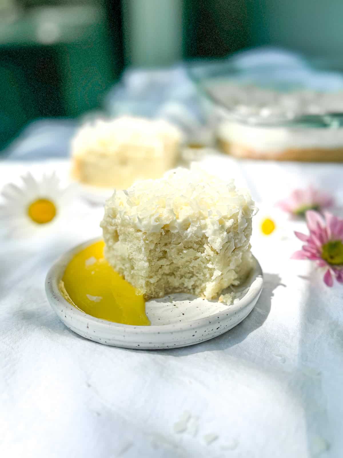 Coconut cake with lemon curd on a white plate.