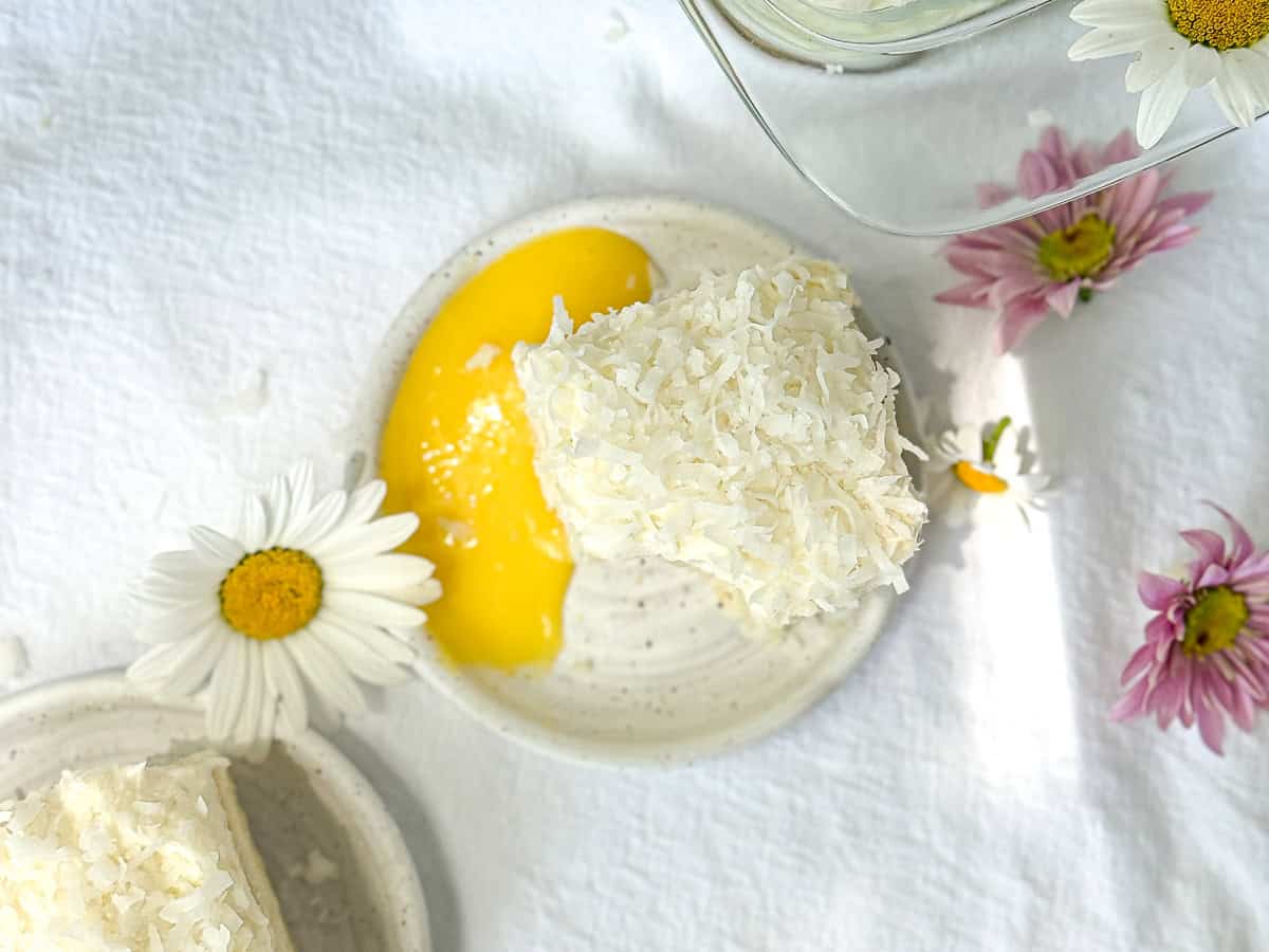 Coconut cake with lemon curd on a white plate.