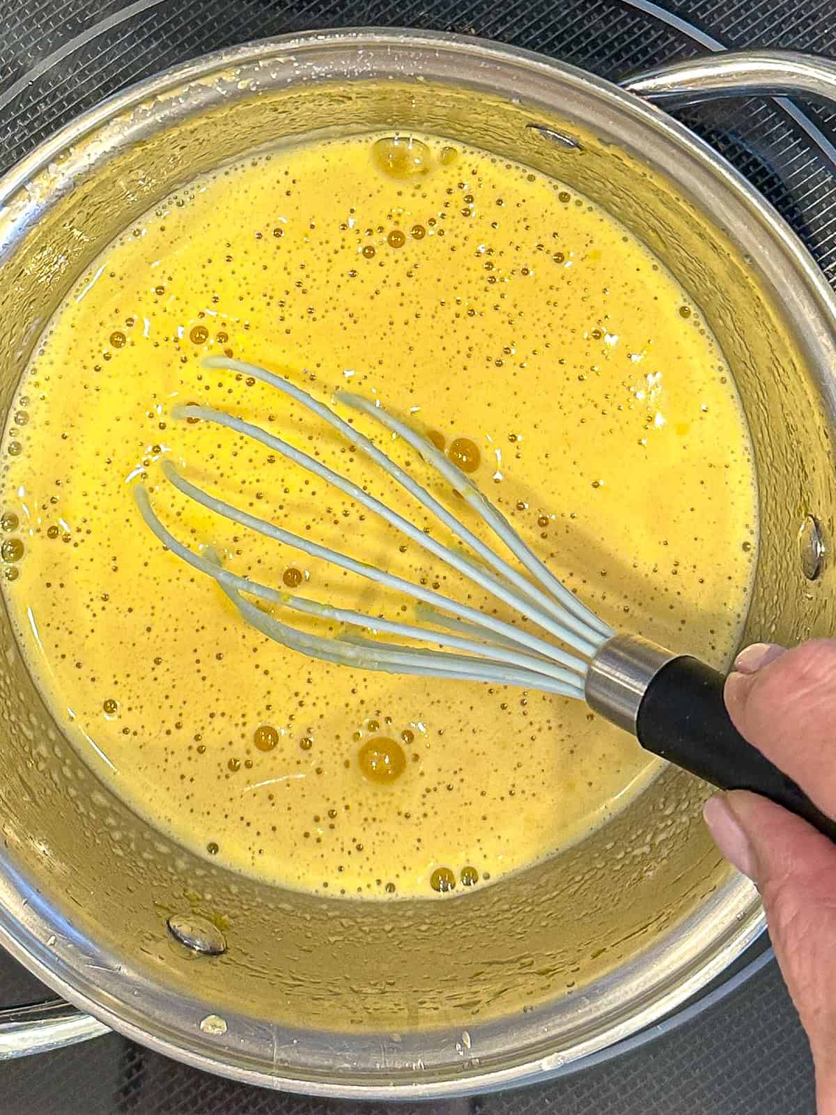 Whisking all of the lemon curd ingredients in a small saucepan.