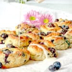 Drizzling lemon glaze over blueberry biscuits.