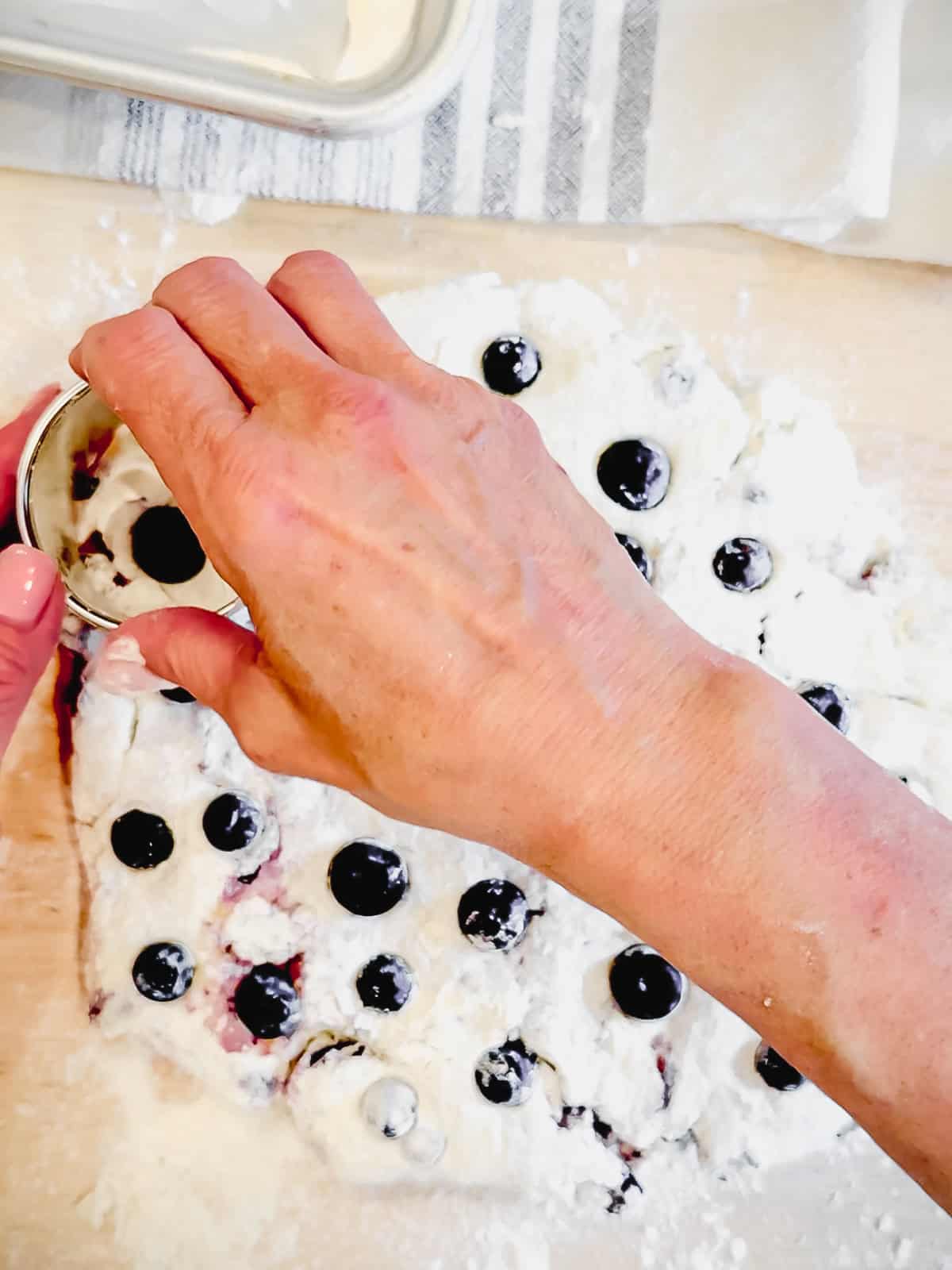 Cutting out blueberry biscuits.