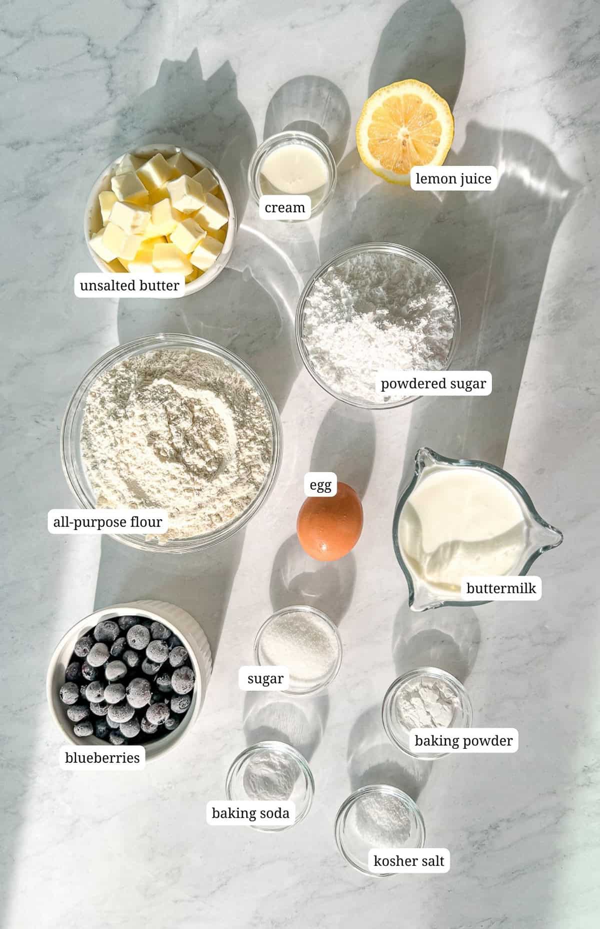 Labeled image of ingredients to make glazed blueberry biscuits.