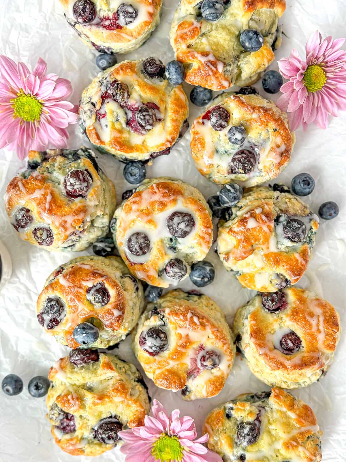 Glazed blueberry biscuits on a white background.