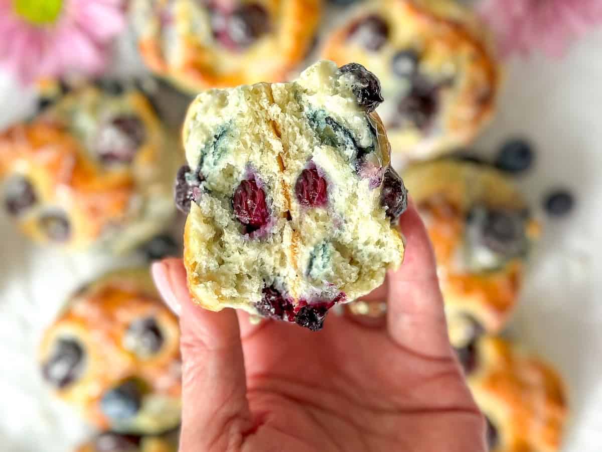 Author holding a glazed blueberry biscuit.