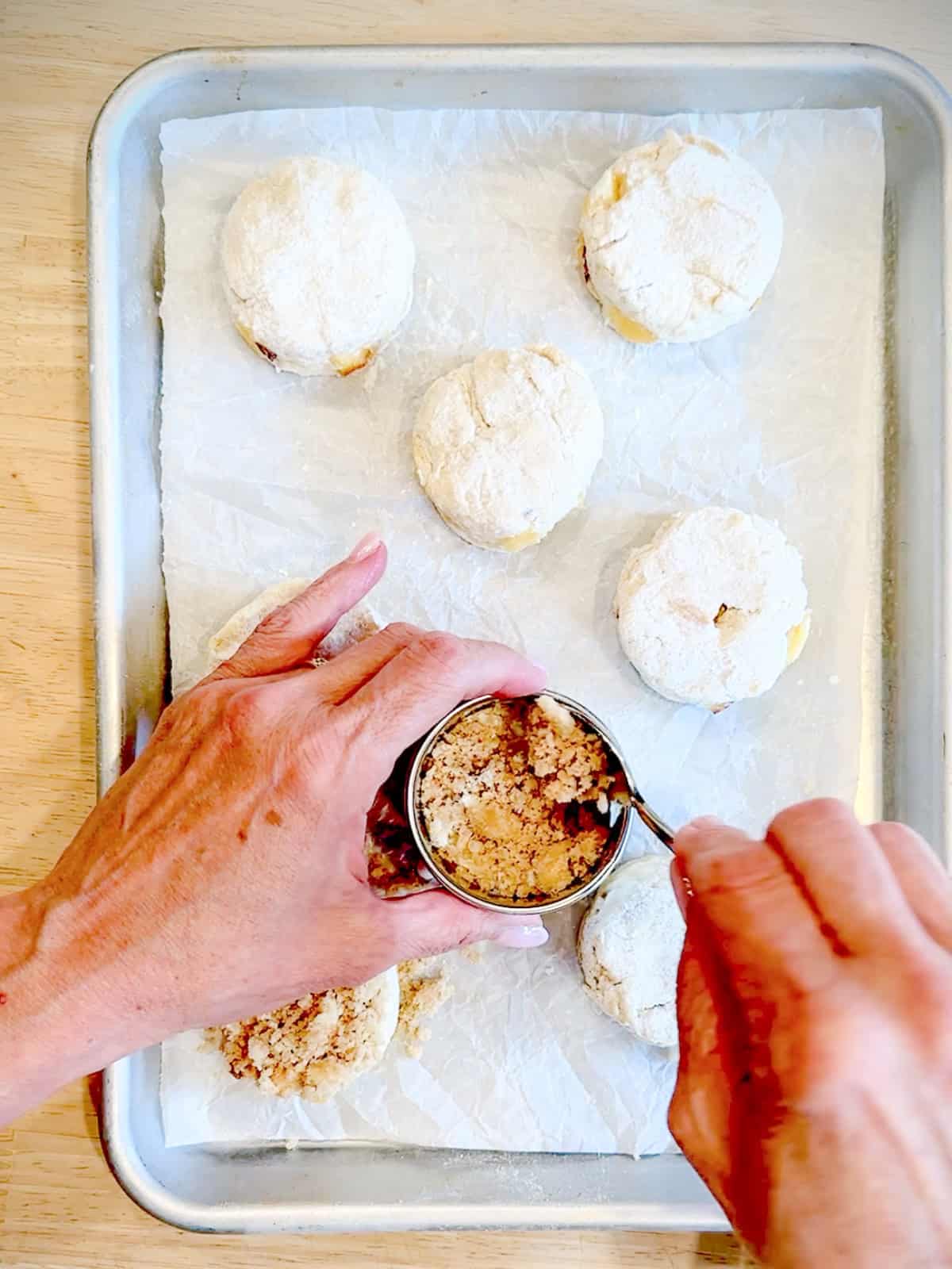 Add streusel to the top of peach biscuits.