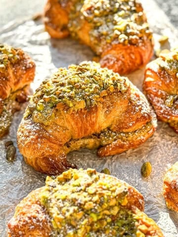 Pistachio croissants on parchment paper.