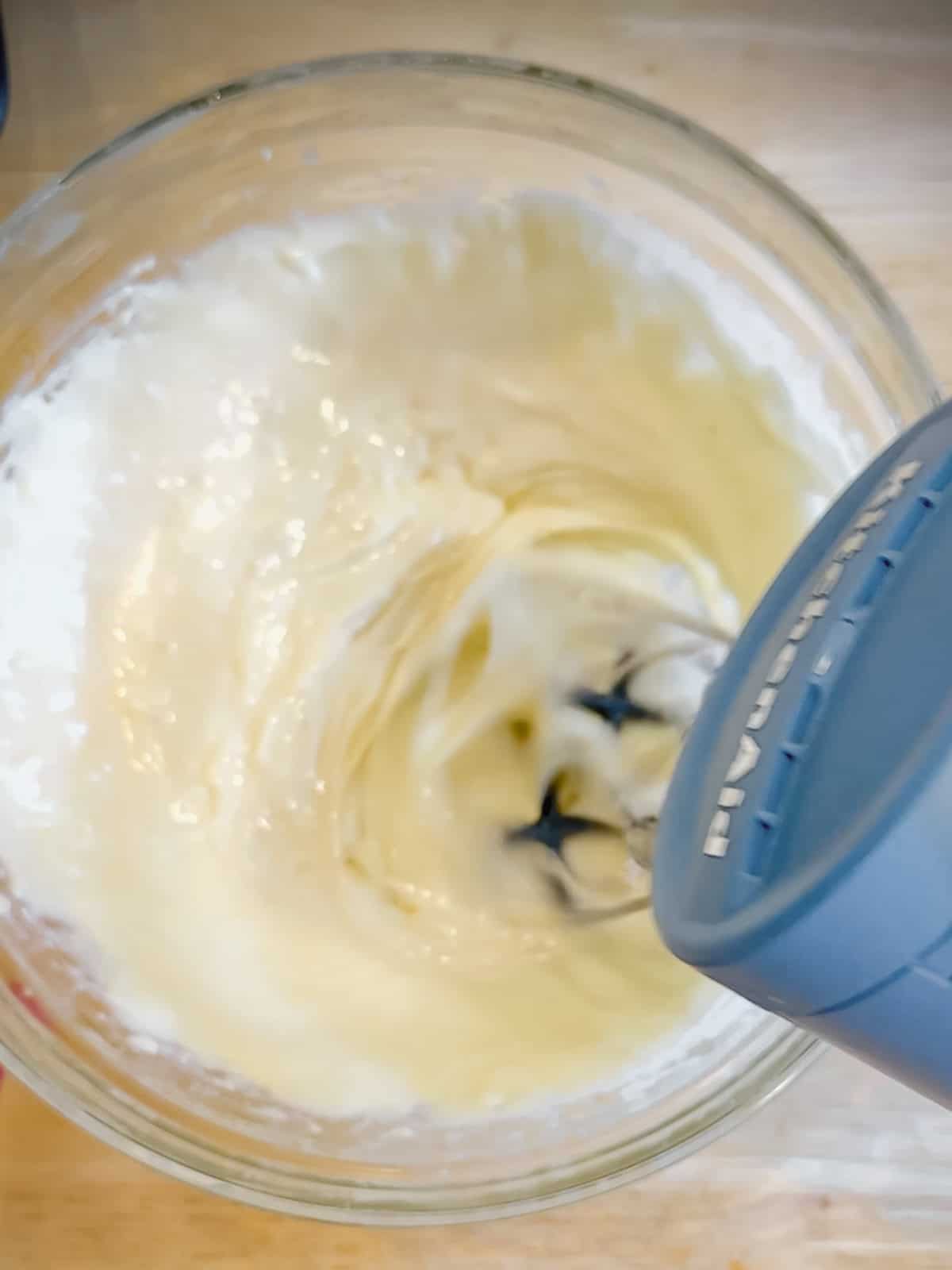 Using a hand mixer to make cream cheese icing.