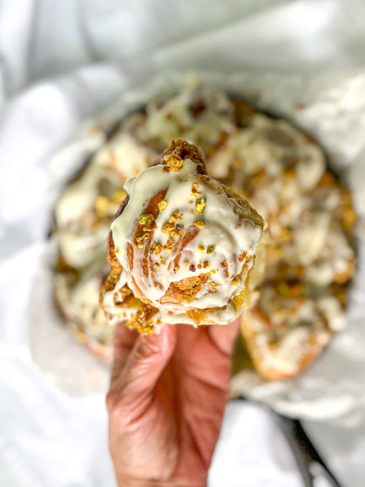 Author's hand holding a pistachio roll.