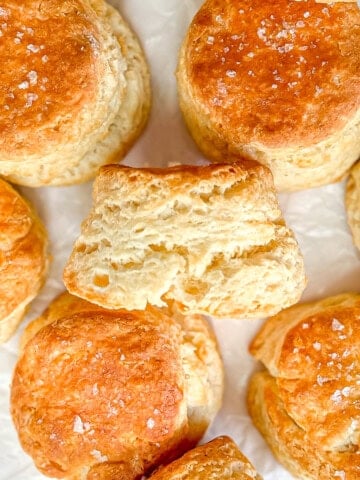 Fluffy homemade biscuits on parchment paper.