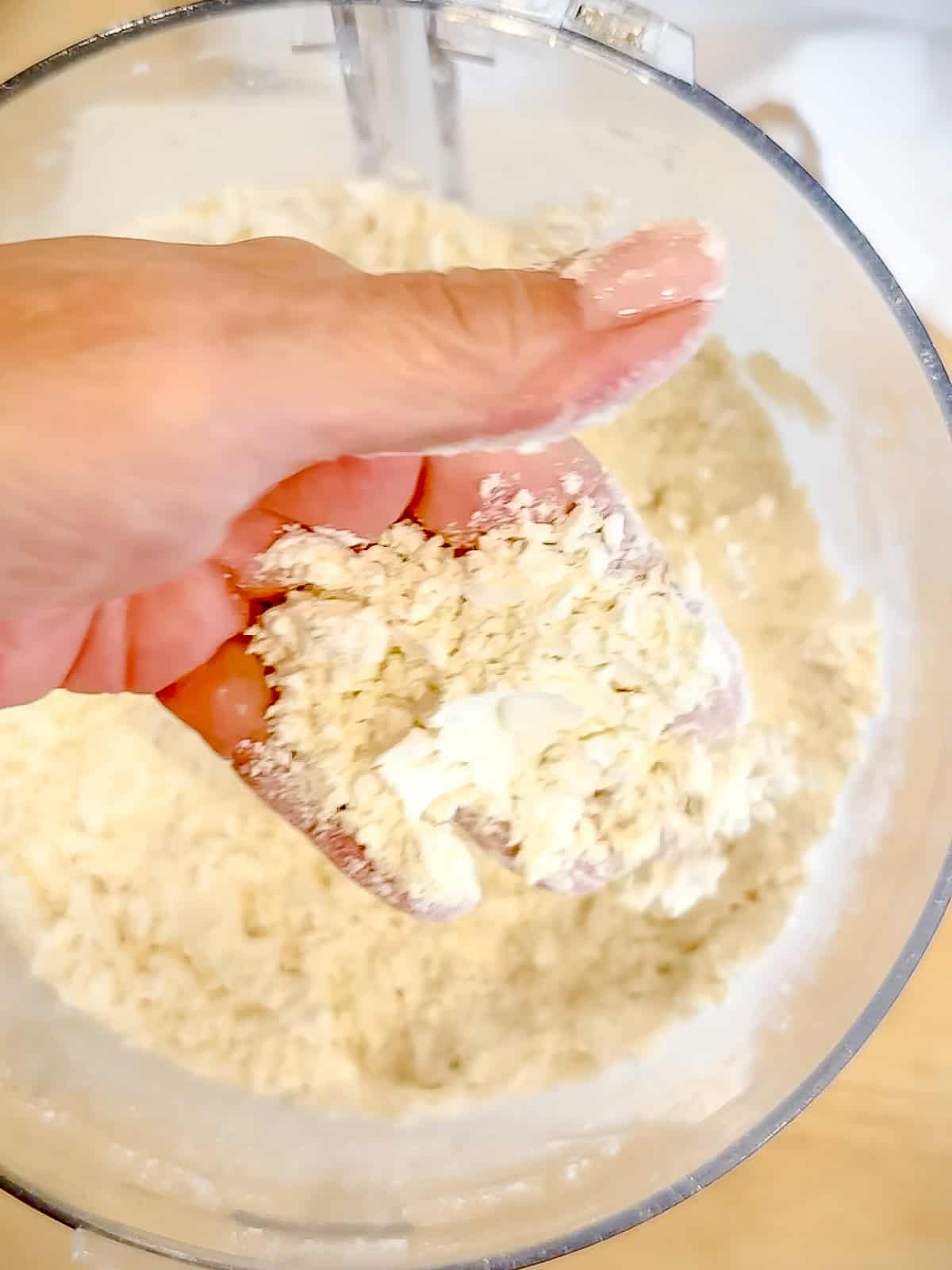 Author's hand holding flour and butter mixture.