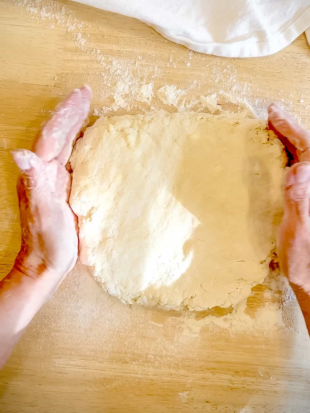 Patting biscuit dough out before cutting them out.