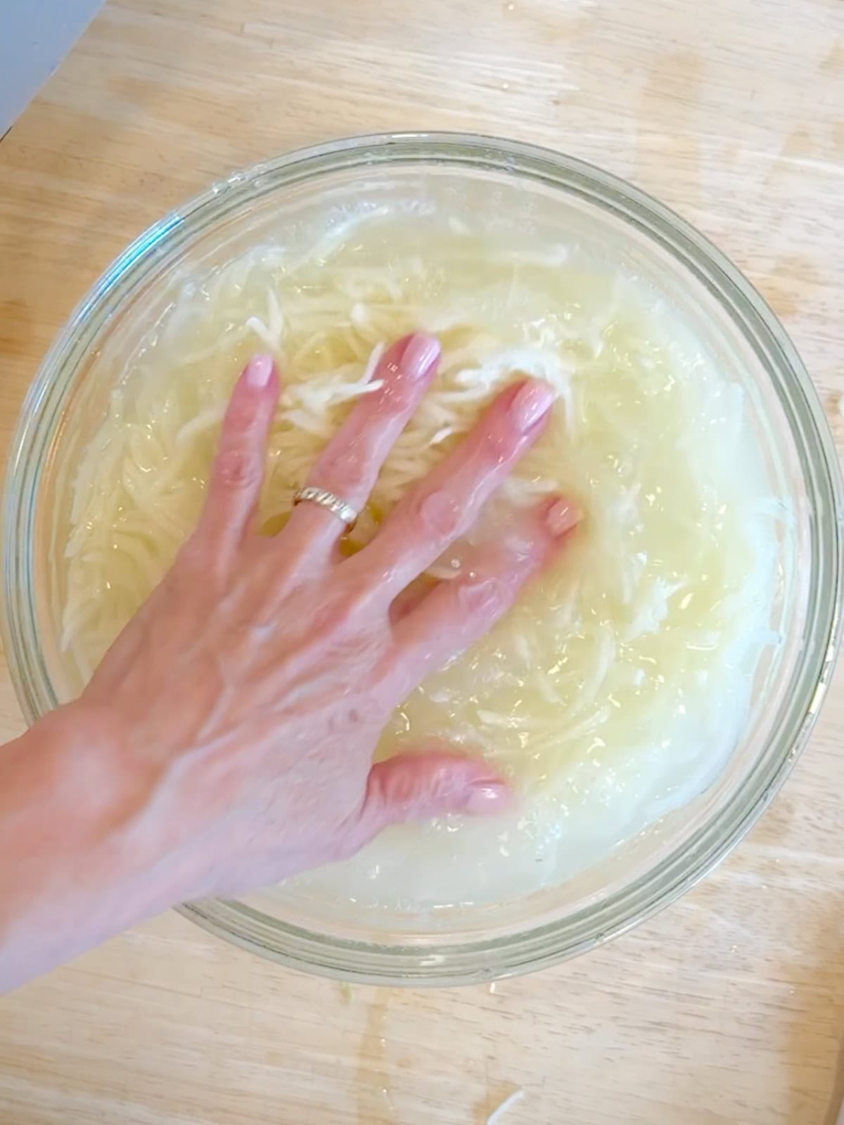 Soaking shredded potatoes in cold water.