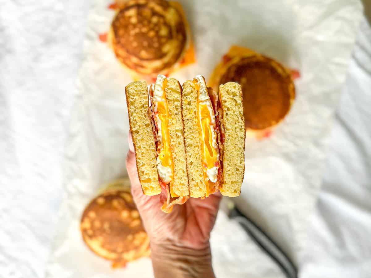 The authors hand holding a sliced open, homemade mcgriddle.