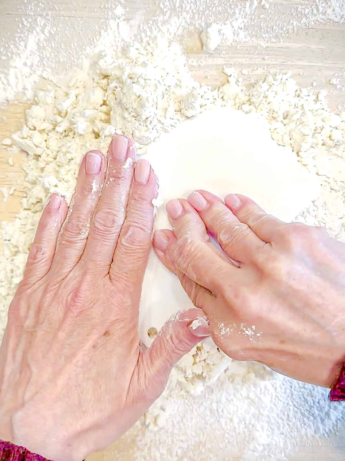 Bringing together two ingredient flatbread dough on a lightly floured surface.