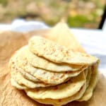 Folded stack of two ingredient flatbread on a piece of parchment paper.