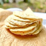 Folded stack of two ingredient flatbread on a piece of parchment paper.