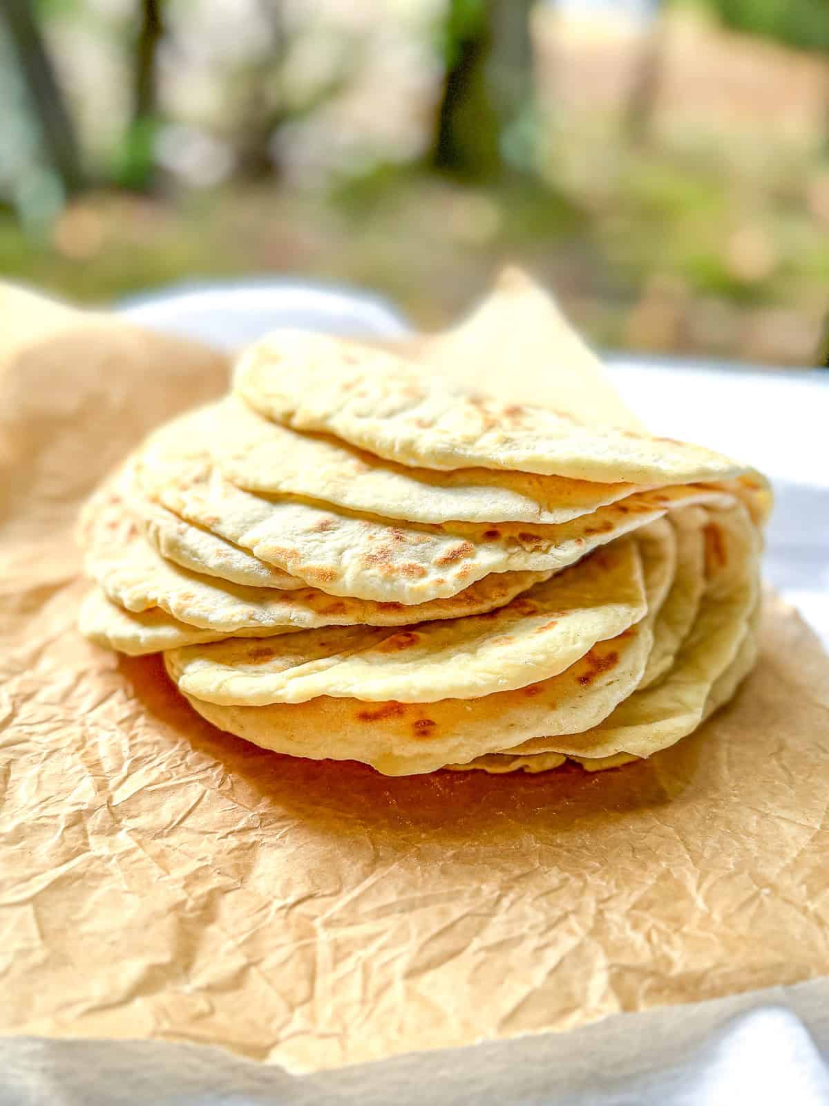 Folded stack of two ingredient flatbread on a piece of parchment paper.